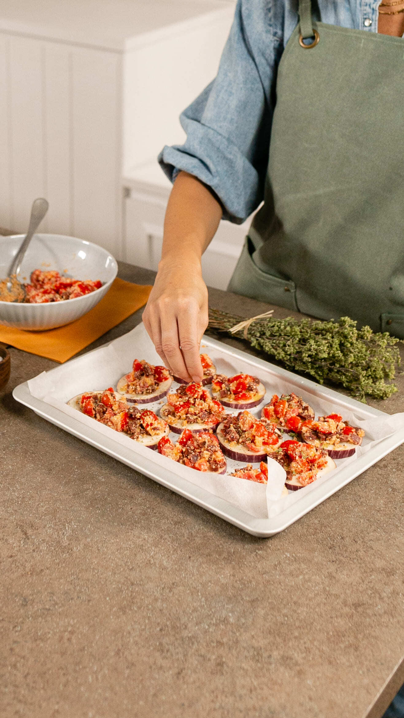 Distribuisci il ripieno precedentemente preparato sulle fettine di melanzana, aggiungi un filo d’olio e spolverizza con l’origano secco.